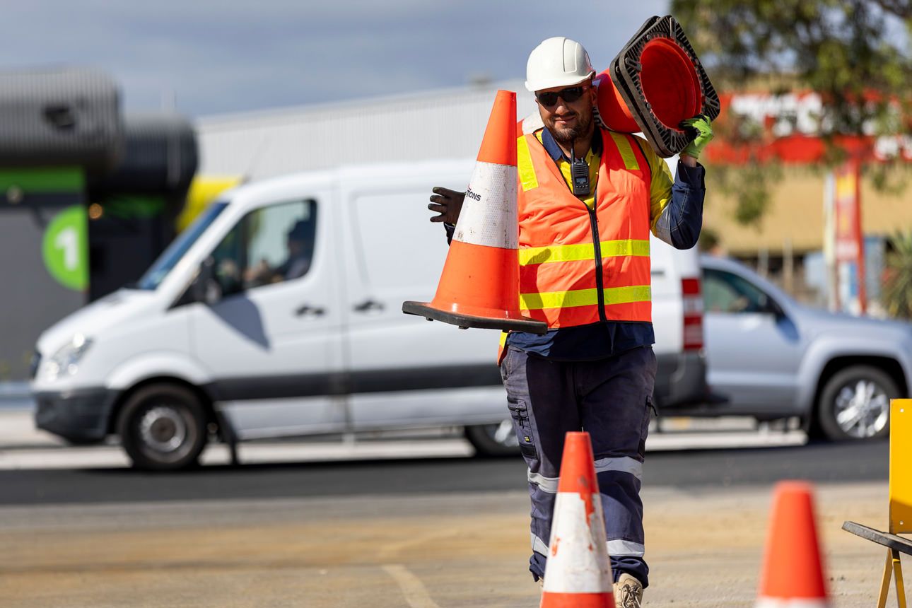 Traffic management male  employee laying out witches hats